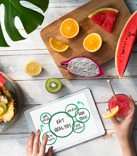 Nutritionist and client reviewing meal plan beside bowl of fresh vegetables