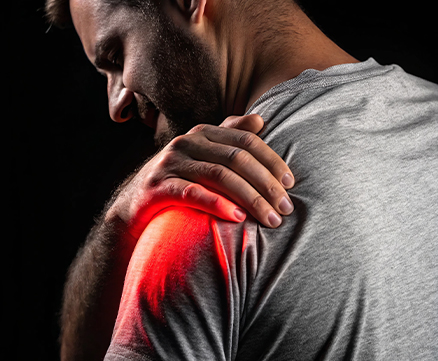 Acupuncturist inserting thin needle into patient’s shoulder on padded table