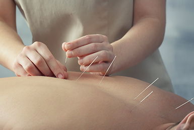 Exterior of Portland acupuncture clinic entrance with signage and large front windows