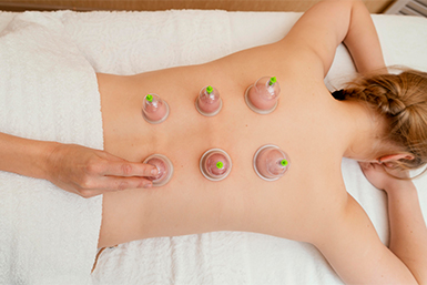 Patient relaxing on treatment table with acupuncture needles along shoulders and neck